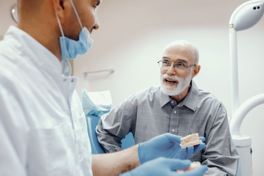 Senior Citizen Consulting With Dentist About Dental Bridge